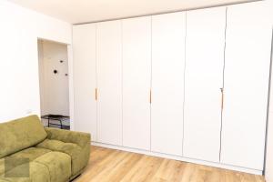 札勒烏的住宿－Urban Nest，客厅配有白色橱柜和绿色沙发
