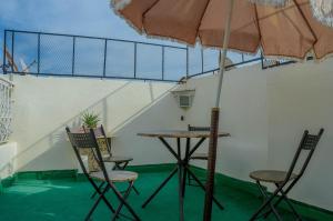 ein Tisch und Stühle mit einem Sonnenschirm in einem Zimmer in der Unterkunft LA casa Dar Rayan in Fès