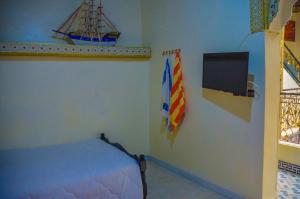ein Schlafzimmer mit einem Bett, einem Fernseher und einer Flagge in der Unterkunft LA casa Dar Rayan in Fès