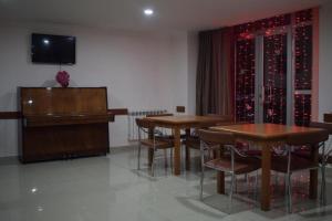 uma sala de jantar com duas mesas e um piano em Nur Hotel em Yerevan