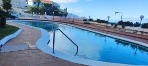 una piscina con un pasamanos en el medio en Apartamento en icod de Los Vinos, playa San Marcos, en San Marcos