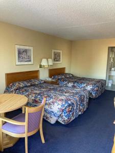 Winnsboro的住宿－FAIRFIELD MOTEL OF WINNSBORO，酒店客房设有两张床和一张桌子。