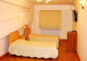 mały pokój z 2 łóżkami i telewizorem w obiekcie Nur Hotel w Erywaniu