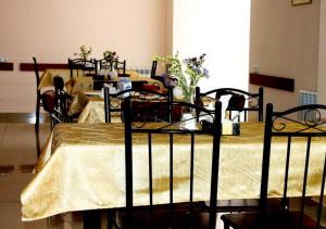Nur Hotel في يريفان: غرفة بثلاث طاولات مع كراسي وطاولة مع ورد