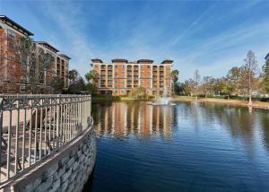 Vue sur un lac avec un bâtiment en arrière-plan dans l'établissement Designer Corner Suite 3BR/2BA -Disney & Universal, à Orlando