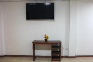 een kamer met een tafel en een tv aan de muur bij Majahual Resort in El Majahual