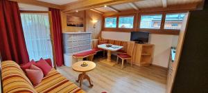 een kleine woonkamer met een bank en een tafel bij Appartements Alpenland - Ferienwohnungen in Auffach