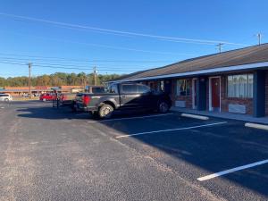 Winnsboro的住宿－FAIRFIELD MOTEL OF WINNSBORO，停在大楼旁停车场的卡车