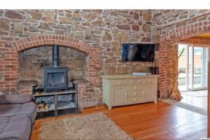 a living room with a brick wall with a fireplace at 2 Bed Sandstone Residence in Newport