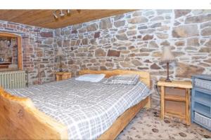 1 dormitorio con cama y pared de piedra en 2 Bed Sandstone Residence, en Newport