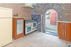 a kitchen with a stove and a stone wall at 2 Bed Sandstone Residence in Newport