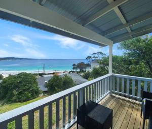 a porch with a view of the beach and the ocean at Bella Costa - Bay of Fires Beach House in Binalong Bay