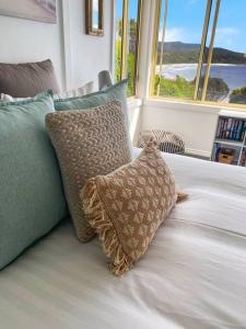 a bed with two pillows on it with a window at Bella Costa - Bay of Fires Beach House in Binalong Bay