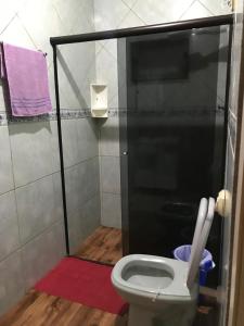 y baño con aseo y cabina de ducha. en Pousada Damasio, en Penha