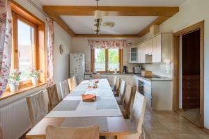 una cocina con una mesa larga y sillas en Villa Morela, en Mikołajki