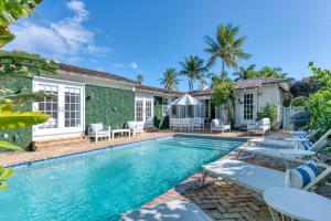 西棕櫚灘的住宿－Maison Papillon Vacation Home，一个带椅子的游泳池以及一座房子