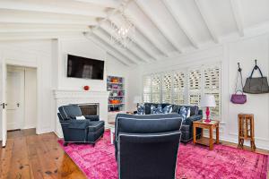 西棕櫚灘的住宿－Maison Papillon Vacation Home，客厅配有蓝色椅子和壁炉