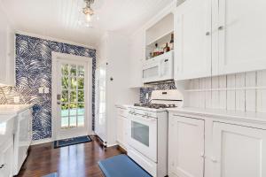 西棕櫚灘的住宿－Maison Papillon Vacation Home，厨房配有白色橱柜和炉灶烤箱。