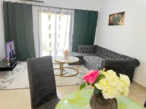 a living room with a couch and a table with flowers at Studio Moderne et Chic in Douala