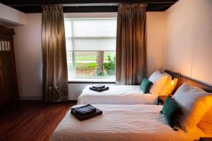 a hotel room with two beds and a window at Pait's Laand Bed & Breakfast in Overschild