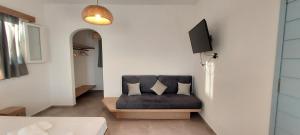 ein Wohnzimmer mit einem Sofa und einem TV in der Unterkunft Casa Di Kimolos in Kimolos