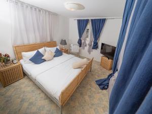 a bedroom with a large bed with blue pillows at Hotel Rhyhof in Frauenfeld
