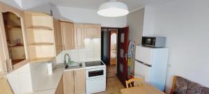 a small kitchen with a white refrigerator and a table at Central Apartments View in Gdańsk