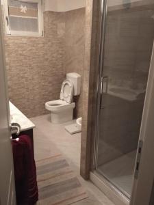 ein Bad mit einem WC und einer Glasdusche in der Unterkunft Villa Bersani in CastellʼArquato