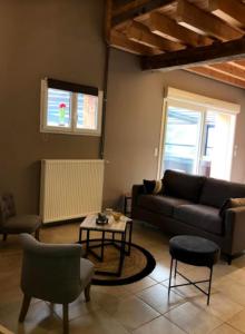 a living room with a couch and a table at Gîte la bergerie, piscine chauffée, in Couzon