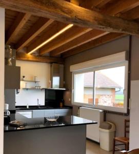 a kitchen with a counter and a large window at Gîte la bergerie, piscine chauffée, in Couzon