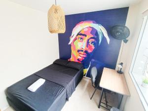 a bedroom with a black bed and a painting on the wall at Casa Clandestina in Medellín