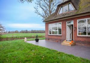 a brick house with a dog sitting outside of it at Pait's Laand Bed & Breakfast in Overschild
