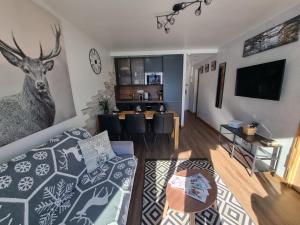 a living room with a couch and a deer head on the wall at Vanoise C in La Daille