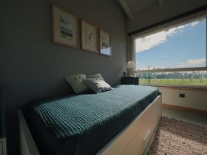 a bedroom with a bed and a large window at La Quintana De José in Muros de Nalón