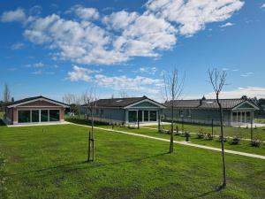 a building with a green yard with trees in the grass at La Quintana De José in Muros de Nalón