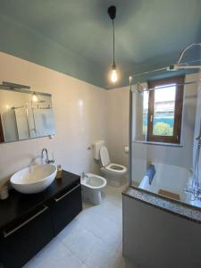a bathroom with two sinks and a toilet and a shower at La casa dei Nonni Guest House in Cuneo