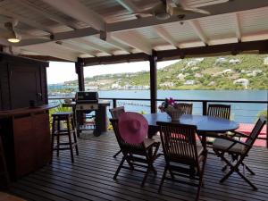 a patio with a table and chairs on a deck at Les Balcons d'Oyster Pond in Saint Martin
