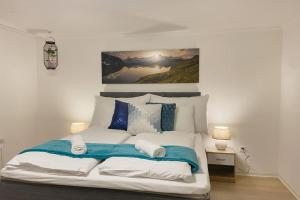 um quarto com uma cama grande e almofadas azuis e brancas em Grubenmann Appartements Herisau em Herisau