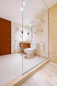 a bathroom with a toilet and a glass shower at Occidental Tucancún - All Inclusive in Cancún