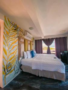 蒙特里科Hotel Maya Jade的一间卧室设有一张大床和色彩缤纷的墙壁