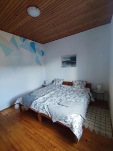 um quarto com uma cama e um tecto de madeira em Family Hostel Pivka em Pivka