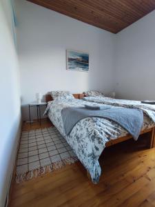 a bed in a white room with a wooden floor at Family Hostel Pivka in Pivka