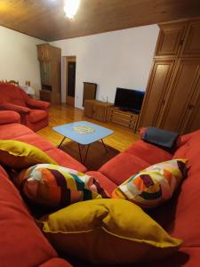 a living room with a red couch and a table at Family Hostel Pivka in Pivka
