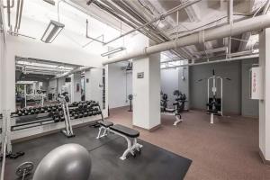 un gimnasio con mucho equipamiento en una habitación en Designer Downtown Condo Suite - Splendid View en Des Moines