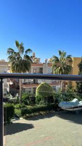 mit Blick auf einen Balkon mit Palmen und Gebäuden in der Unterkunft Cleopatra Uygun Apartment in Alanya