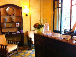 a room with a desk with a vase of flowers on it at La Marjolaine in Juan-les-Pins