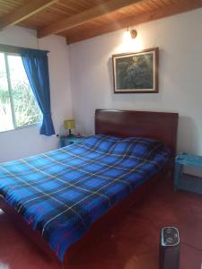 a bedroom with a bed with a blue comforter at Cucunuba por Siempre in El Salitre