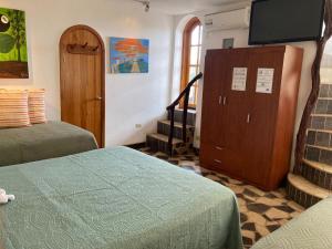 a room with two beds and a flat screen tv at La Fortaleza De Haro in Puerto Ayora +78 photos