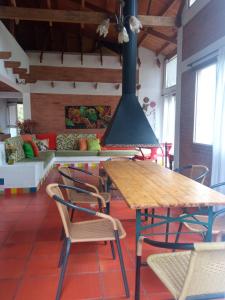 ein Esszimmer mit einem Holztisch und Stühlen in der Unterkunft Cucunuba por Siempre in El Salitre