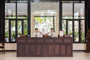duas pessoas sentadas num balcão numa sala com janelas em Saem Siemreap Hotel em Siem Reap